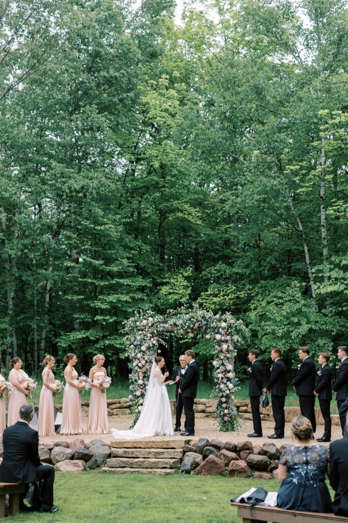 northern haus wedding ceremony in front of wooded area in Door County